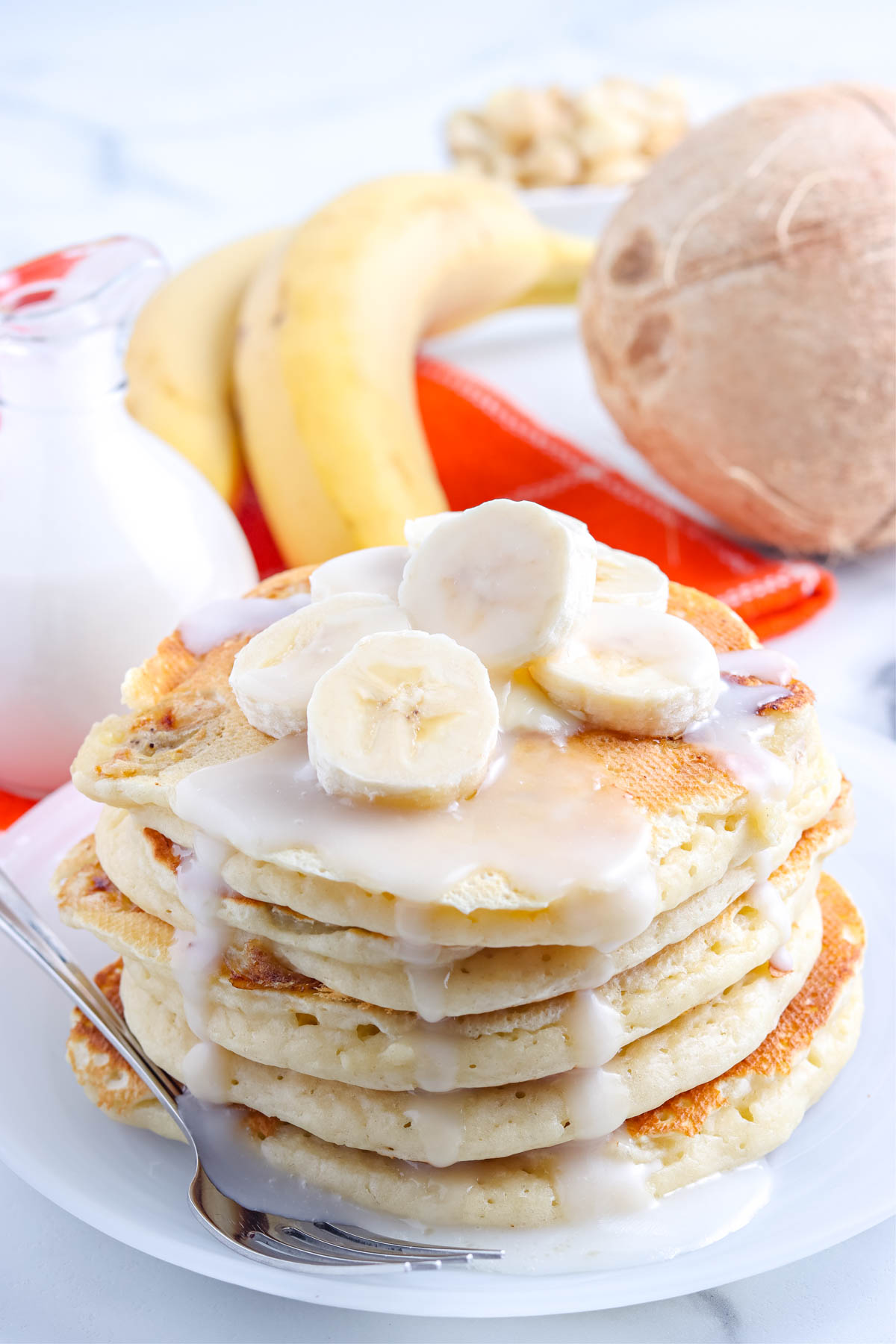 Coconut pancake syrup on a stack of pancakes.
