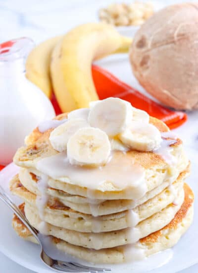 Coconut pancake syrup on a stack of pancakes.