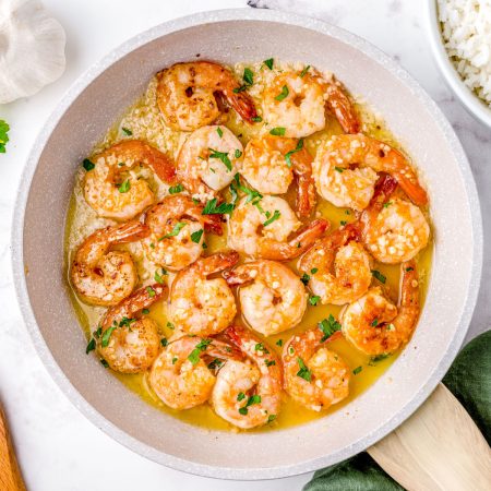 An overhead picture of the finished Hawaiian recipe of garlic shrimp in a pan.
