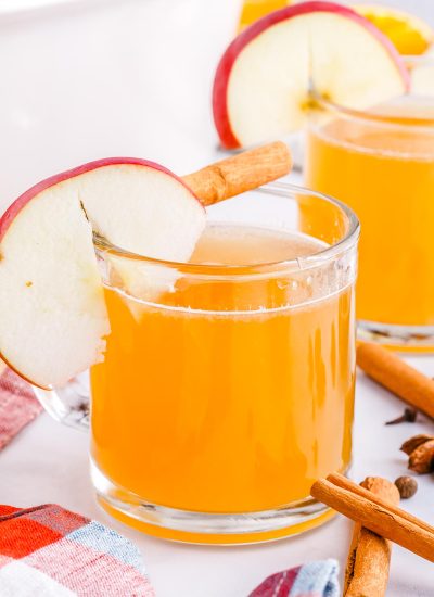 The finished Homemade Apple Cider in a clear glass mug garnished with an apple slice.