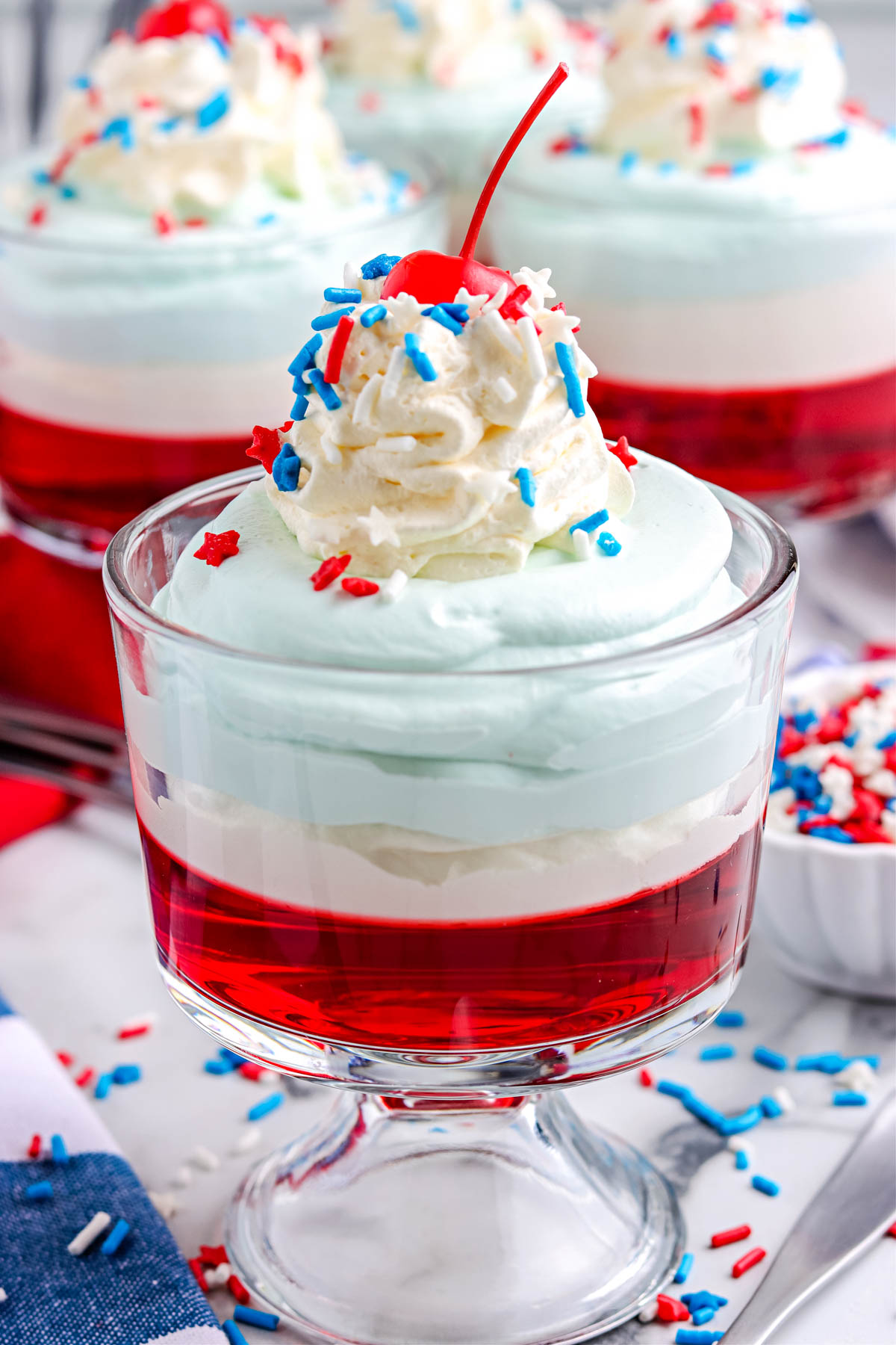 The finished Jello Parfait in a clear glass serving dish decorated with sprinkles.