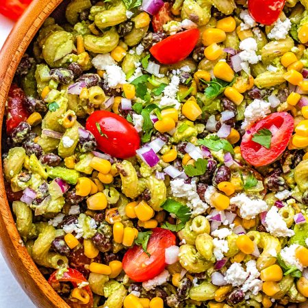 A close up picture of the finished Mexican Pasta Salad recipe in a wooden serving bowl.