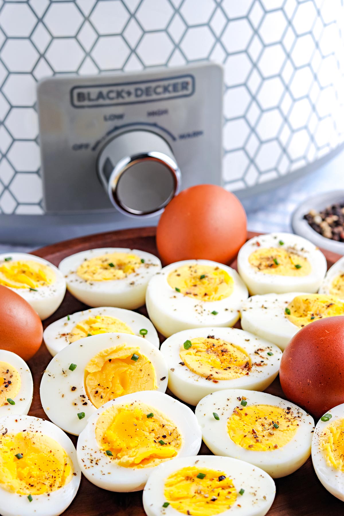 A close up picture of the finished Crock Pot Hard Boiled Eggs cut in half and sprinkled with salt and pepper.