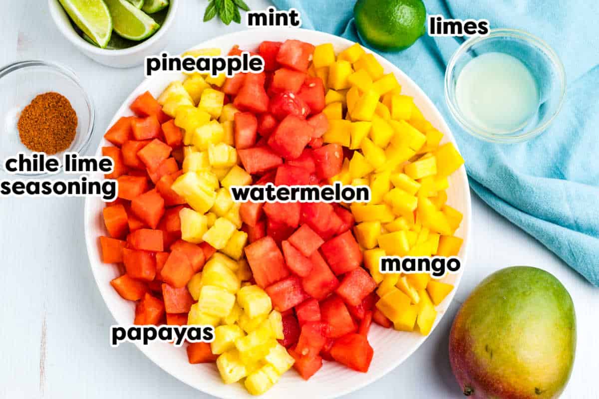Ingredients to make this fruit salad with text overlay labeling each one.