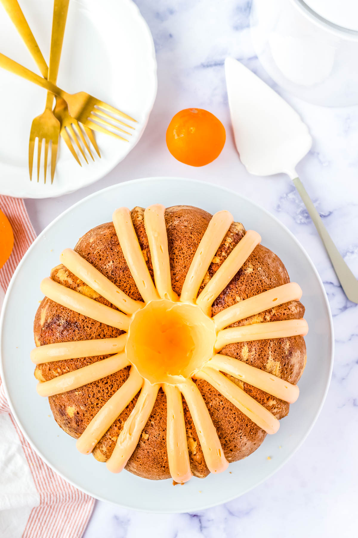 An overhead picture of the finished Orange Creamsicle Bundt Cake on a white platter. 