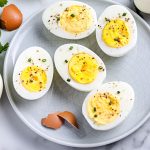 A close up picture of the finished Instant Pot Hard Boiled Eggs on a grey plate.