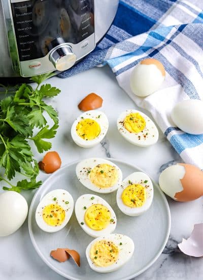 The finished Instant Pot Hard Boiled Eggs on a serving plate with the instant pot in the background.