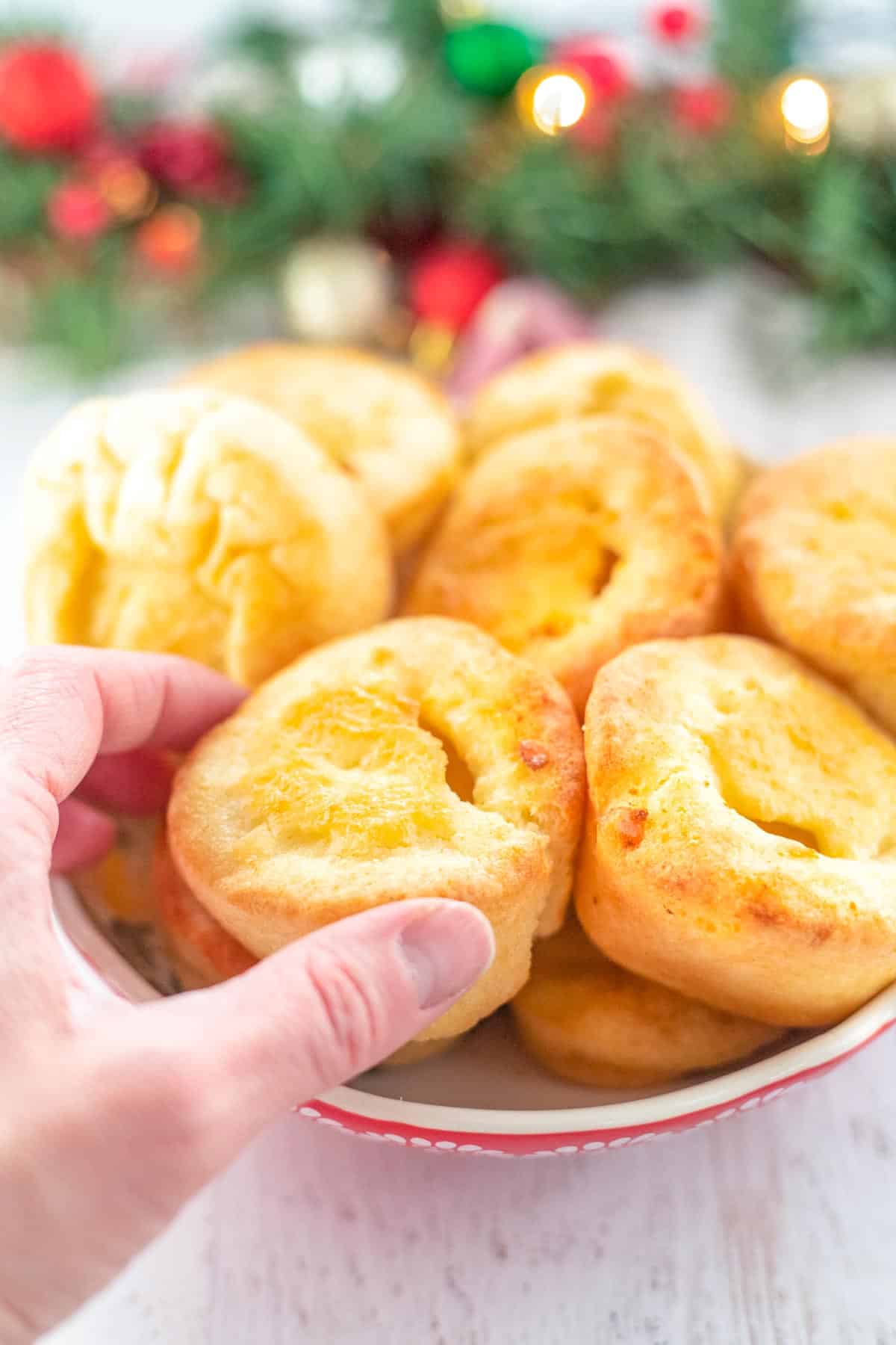 A hand picking up a finished Yorkshire Pudding.