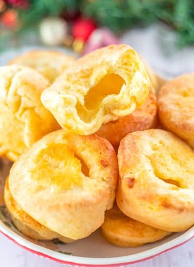The finished Yorkshire Pudding on a serving plate piled on top of each other.