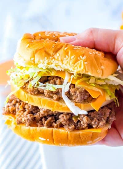 A close up picture of a hand picking up a Big Mac Sloppy Joe.