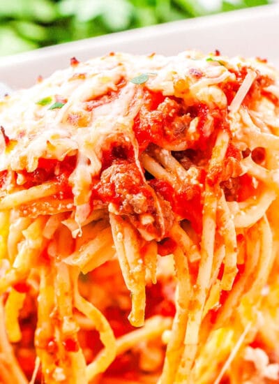 a spatula taking a scoop of baked spaghetti out of a casserole dish