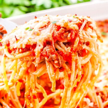 a spatula taking a scoop of baked spaghetti out of a casserole dish