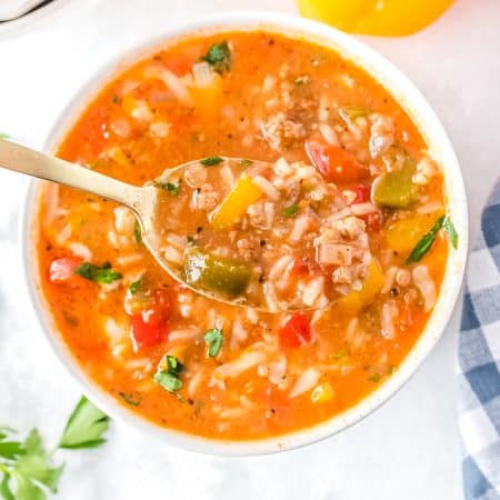 An overhead picture of the finished Instant Pot Stuffed Pepper Soup recipe in a white bowl with a spoon.