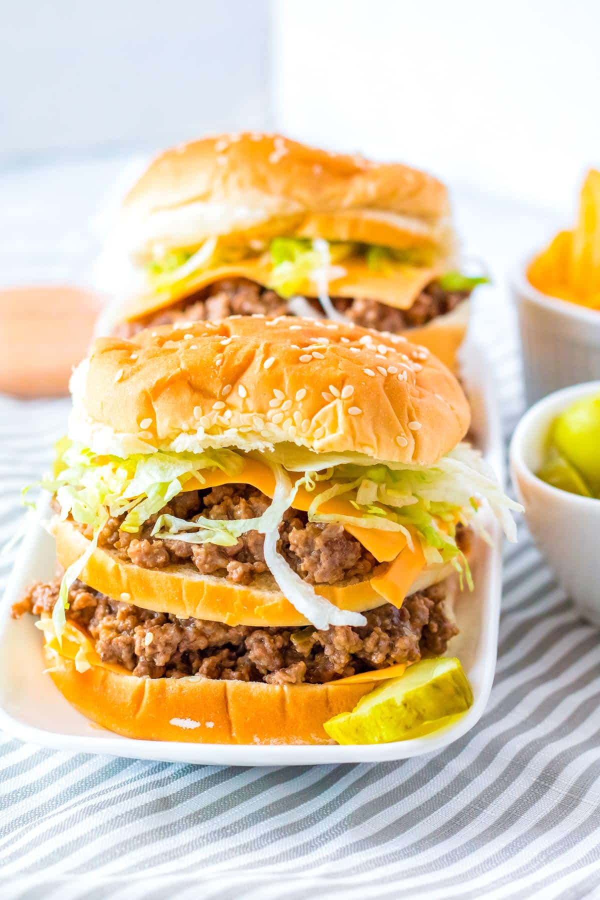 Two finished Big Mac Sloppy Joes on a white serving platter.