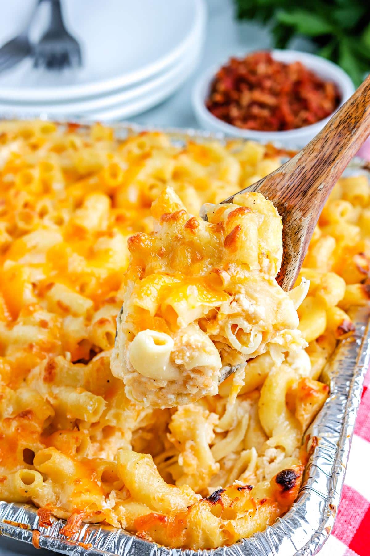 A wooden spoon picking up a spoonful of the finished Smoked Mac and Cheese recipe.