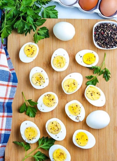An overhead picture of Stovetop Hard Boiled Eggs cut in half on a wooden cutting board.