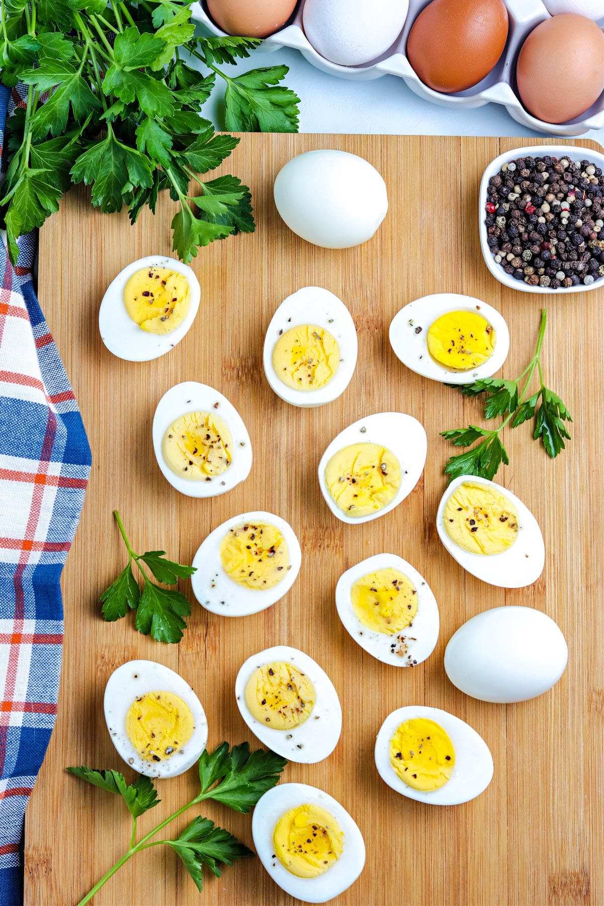 An overhead picture of Stovetop Hard Boiled Eggs cut in half on a wooden cutting board. 
