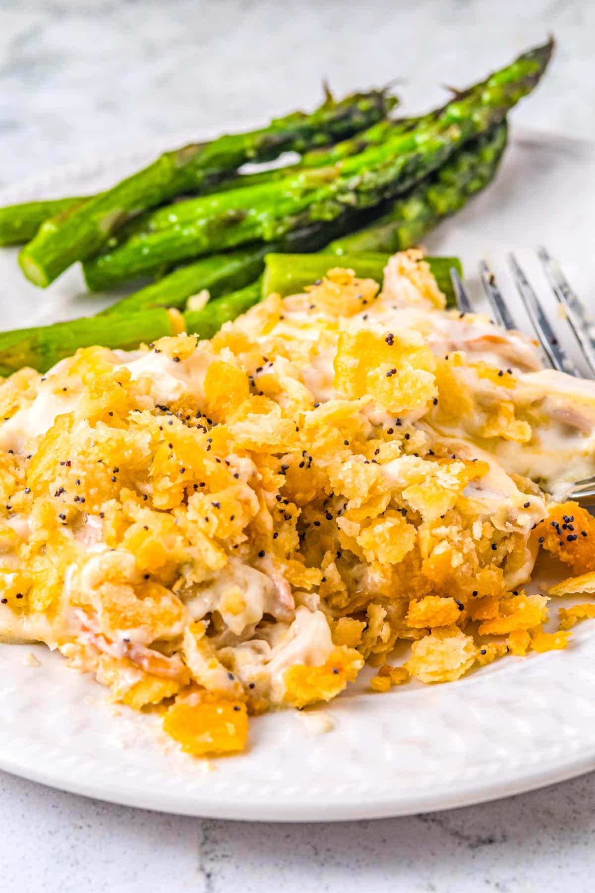 The finished Chicken Poppy Seed Casserole scooped out onto a white plate.