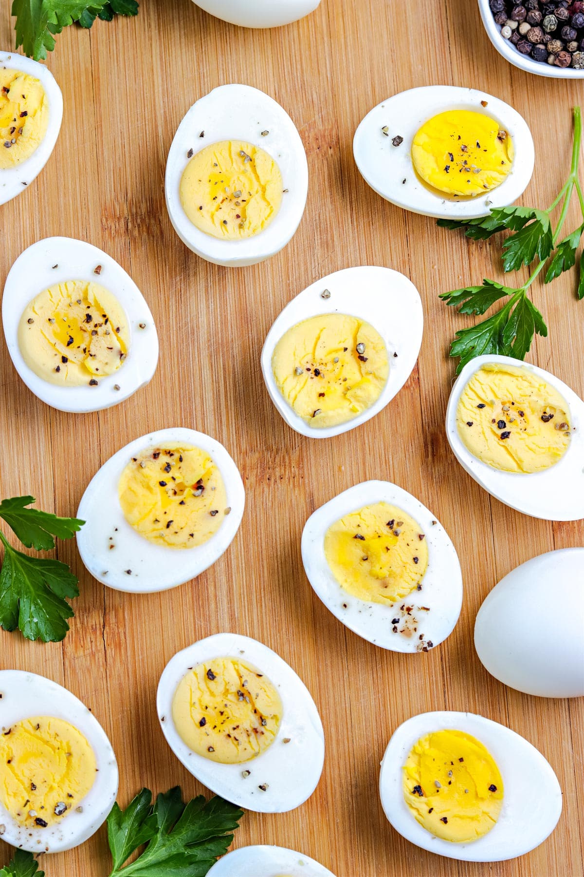 An overhead picture of Hard Boiled Eggs cut in half and sprinkled with salt and pepper