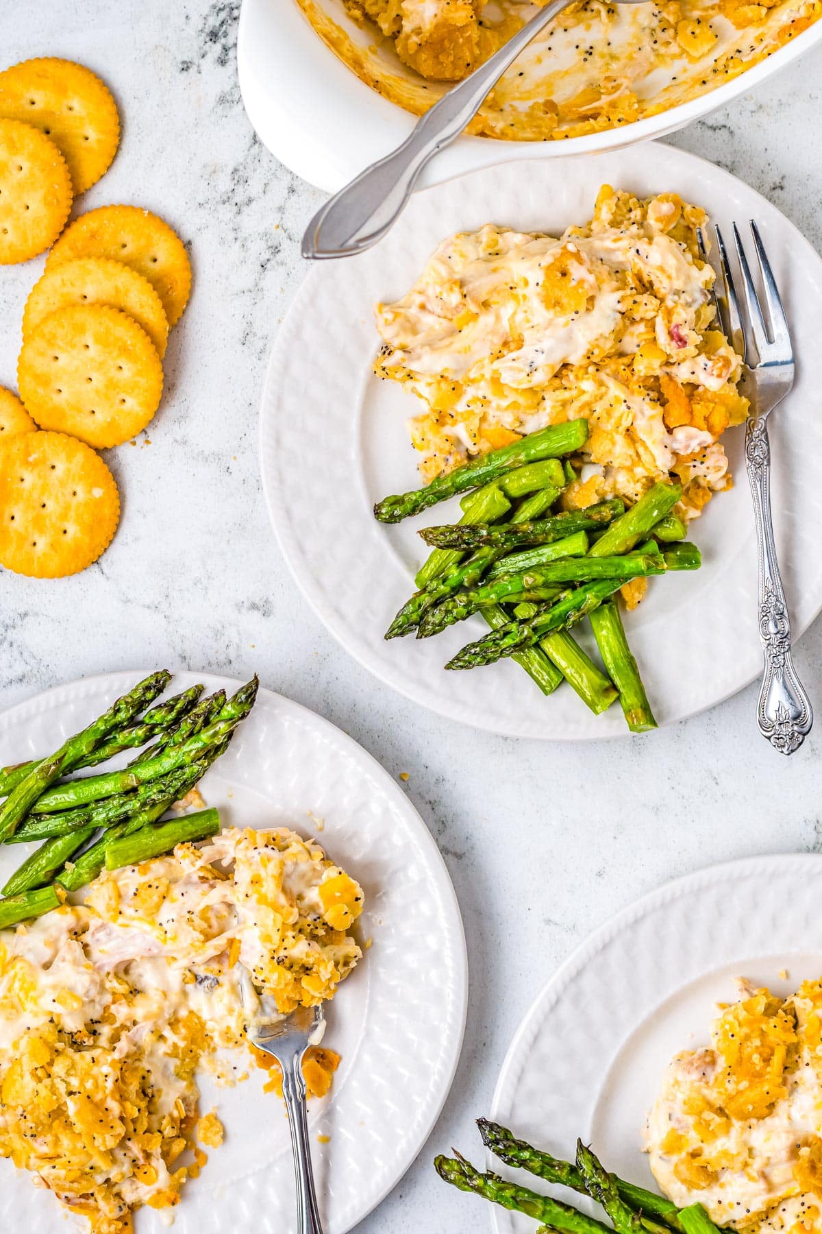 An overhead picture of the finished Poppy Seed Chicken Casserole recipe scooped out onto white plates.