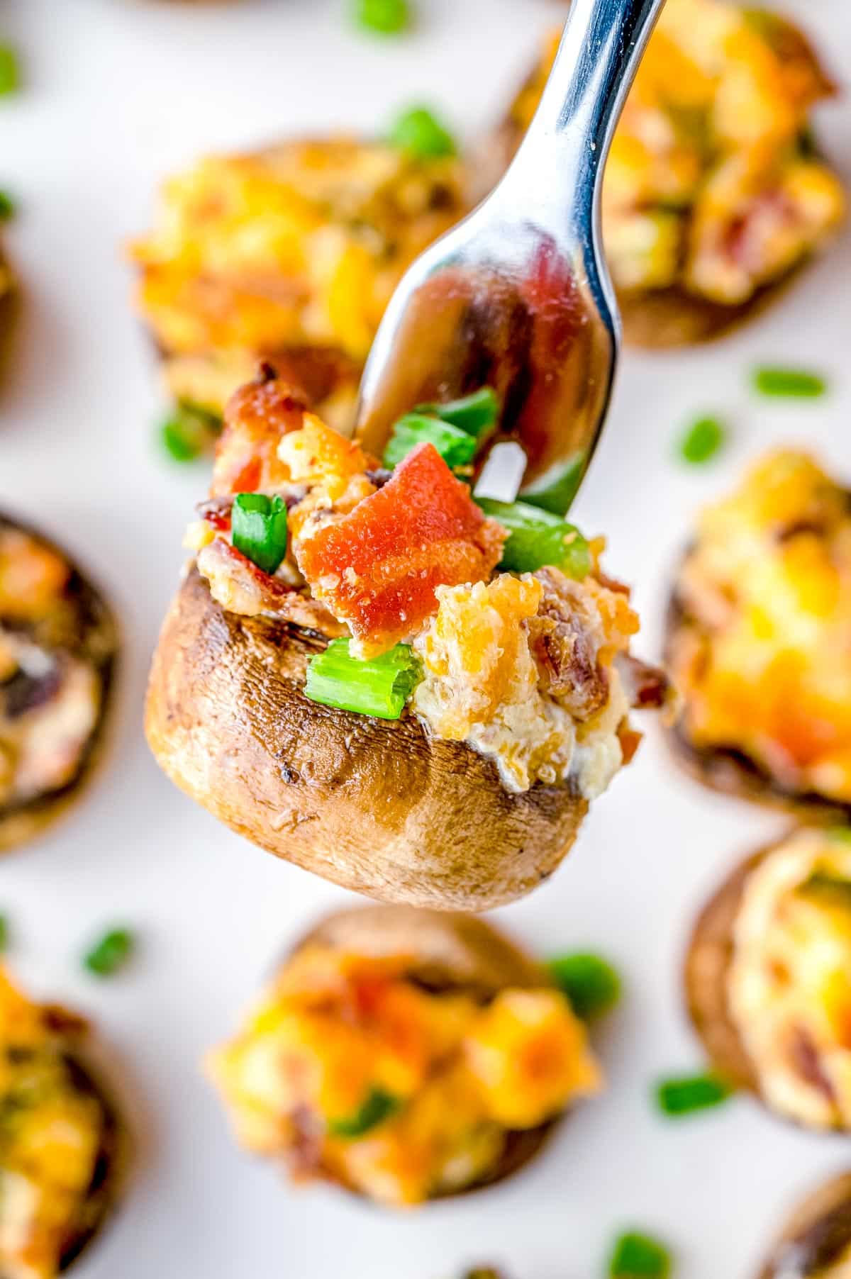 A fork picking up a finished Bacon Stuffed Mushroom.
