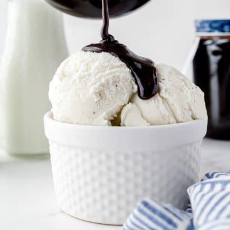 A close up picture of the finished Chocolate Syrup recipe being poured over ice cream.