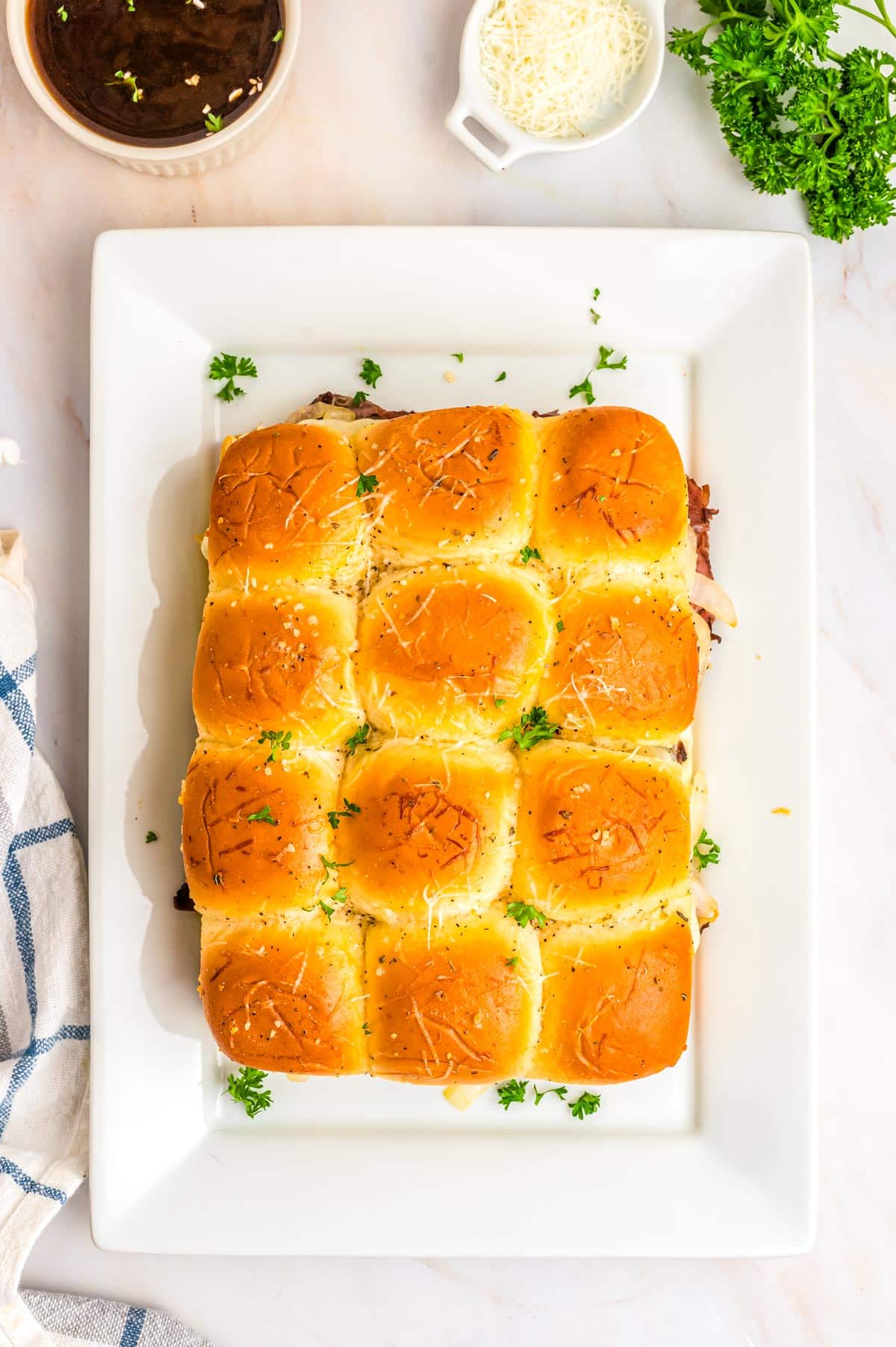 An overhead picture of he finished French Dip Sliders Recipe on a white serving platter.