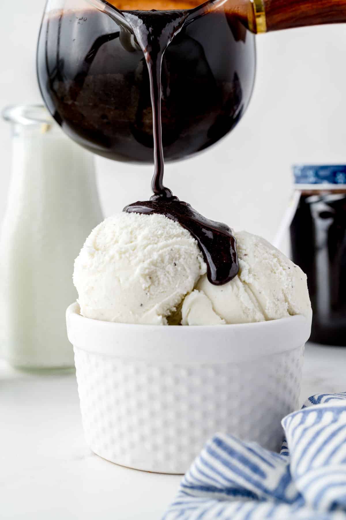 Homemade Chocolate Syrup being poured over ice cream. 