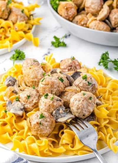 A fork digging the finished Meatball Stroganoff served over noodles.