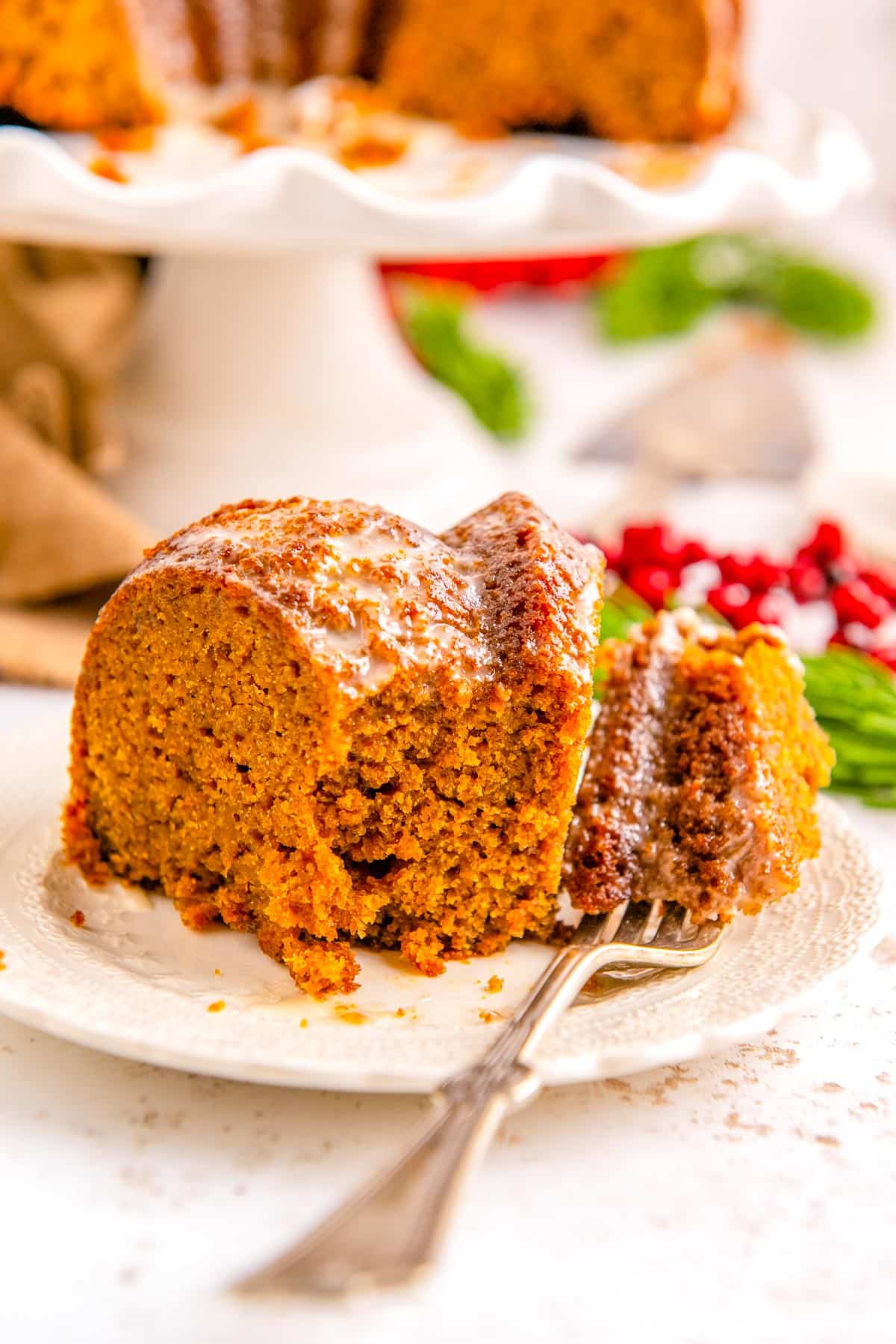 A slice of the finished recipe for gingerbread bundt cake on a white pate.