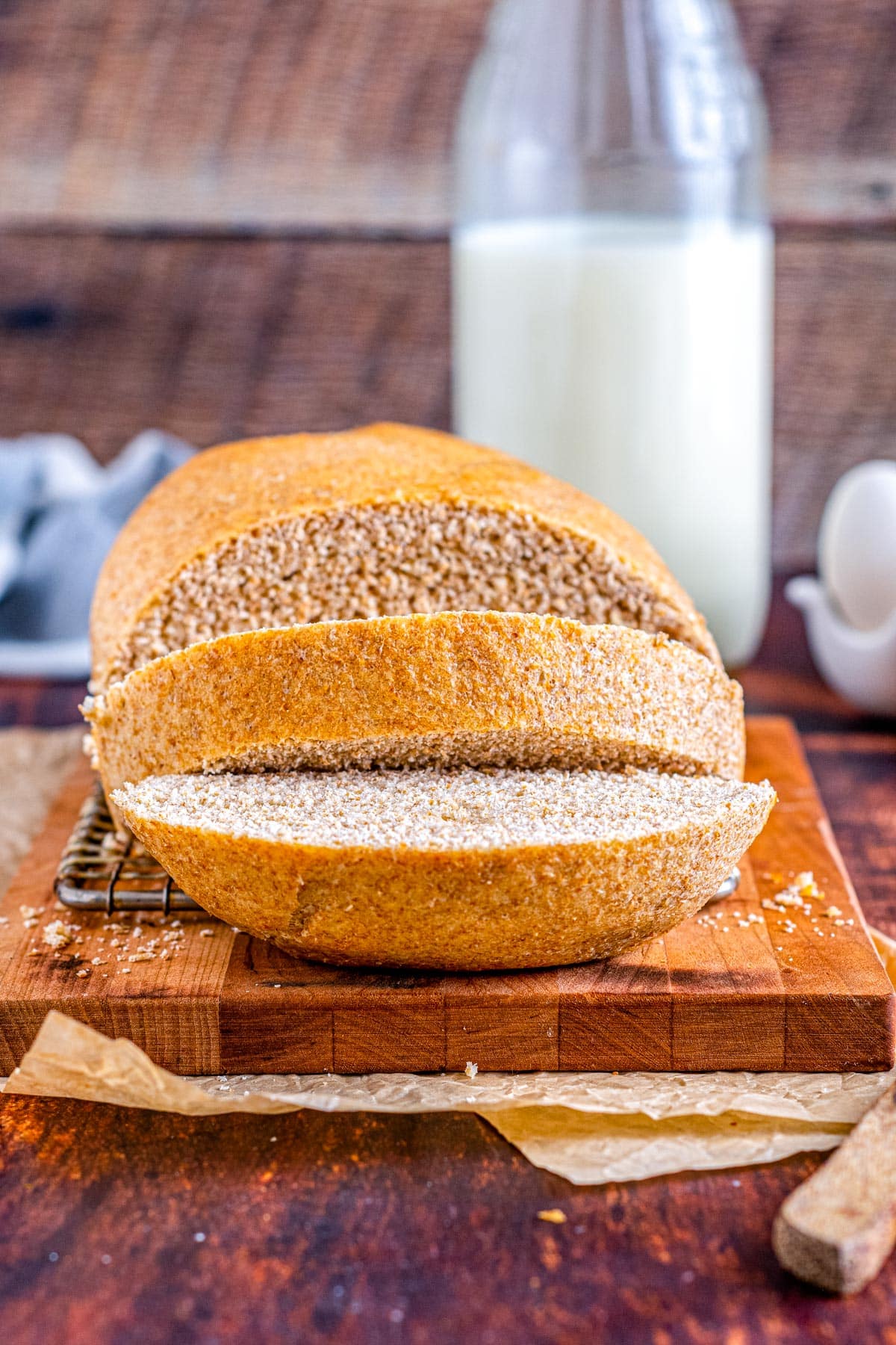 The finished Honey Whole Wheat Bread on a cutting board and part of it cut into.