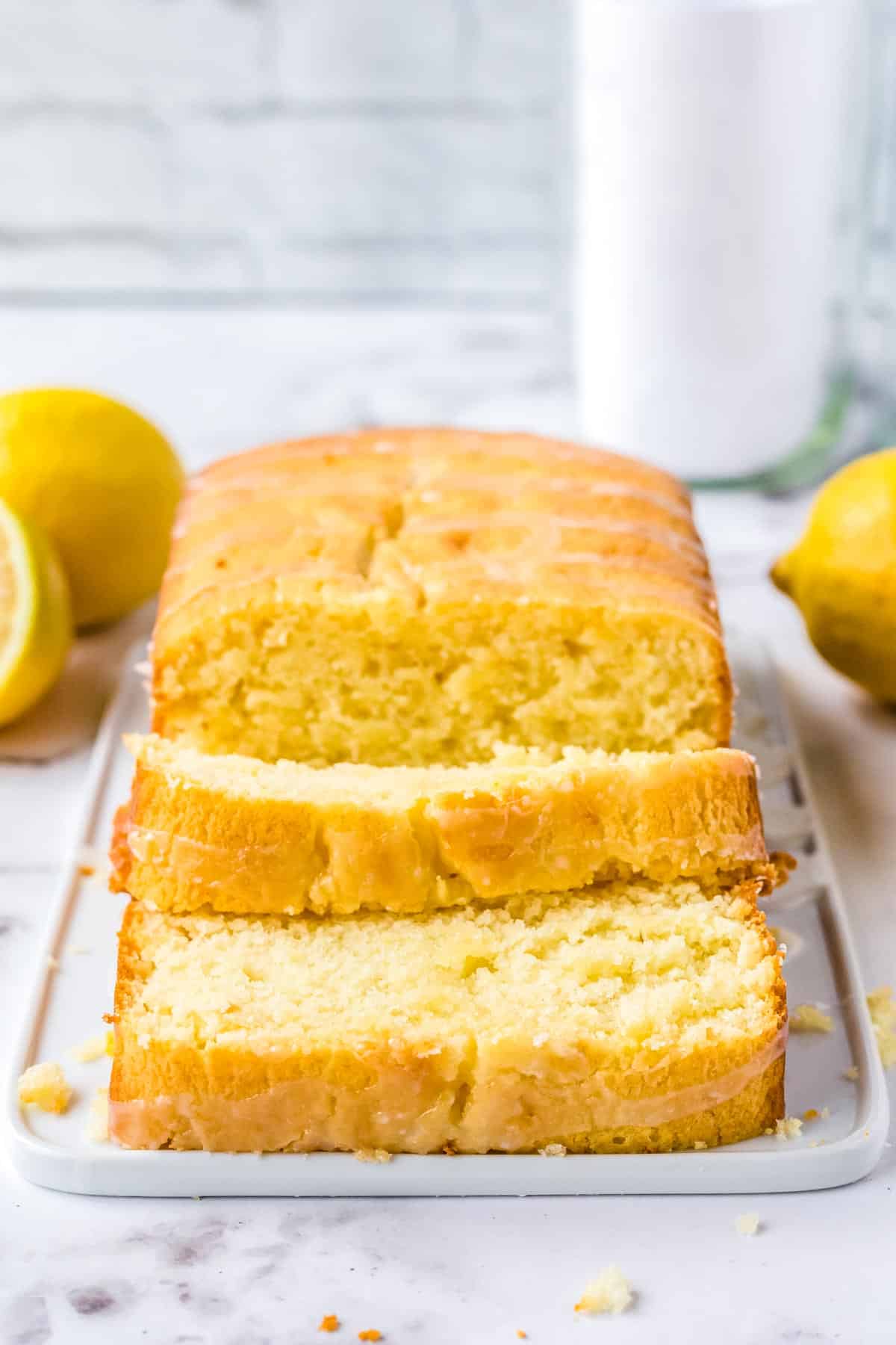 The finished Lemon Glazed Bread sliced and on a white platter.