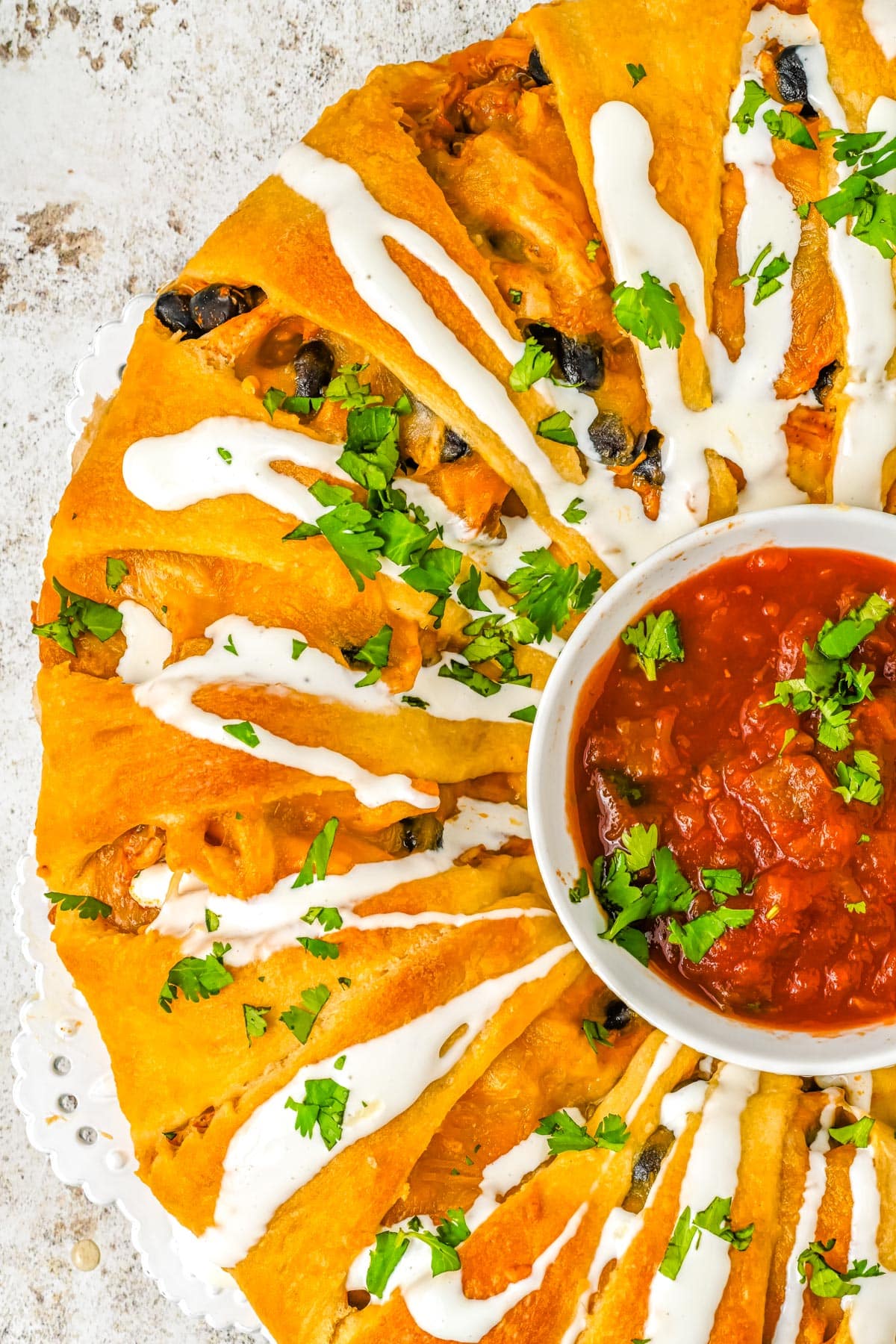 A close up picture of the finished Chicken Enchilada Crescent Roll Wreath on a serving platter. 