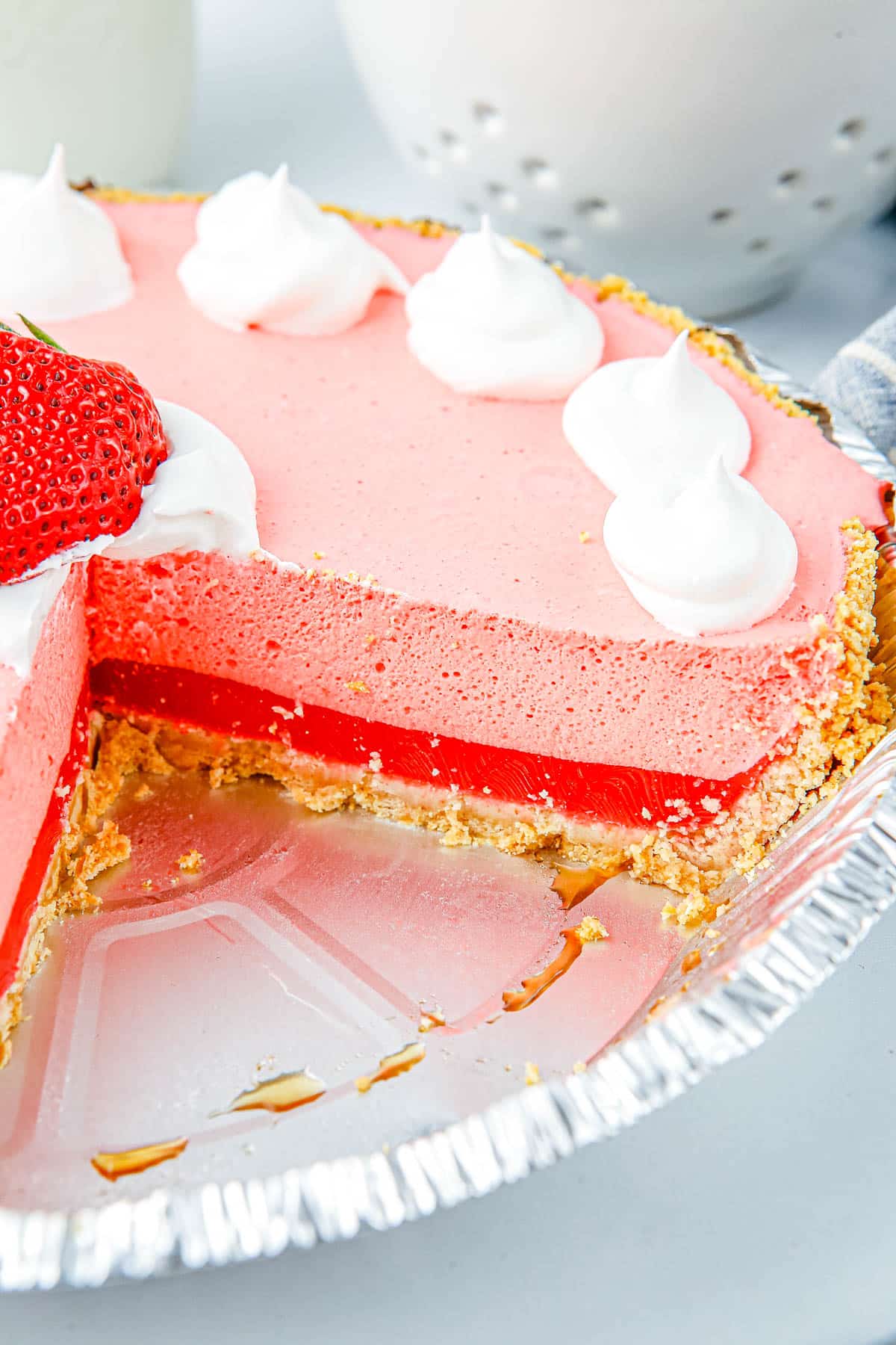 The finished Cool Whip strawberry Jello Pie with a few slices taken out of it so you can se the layers of the pie. 