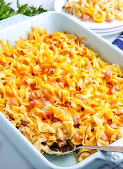 The finished Ham and Noodle Casserole with a serving spoon in it.