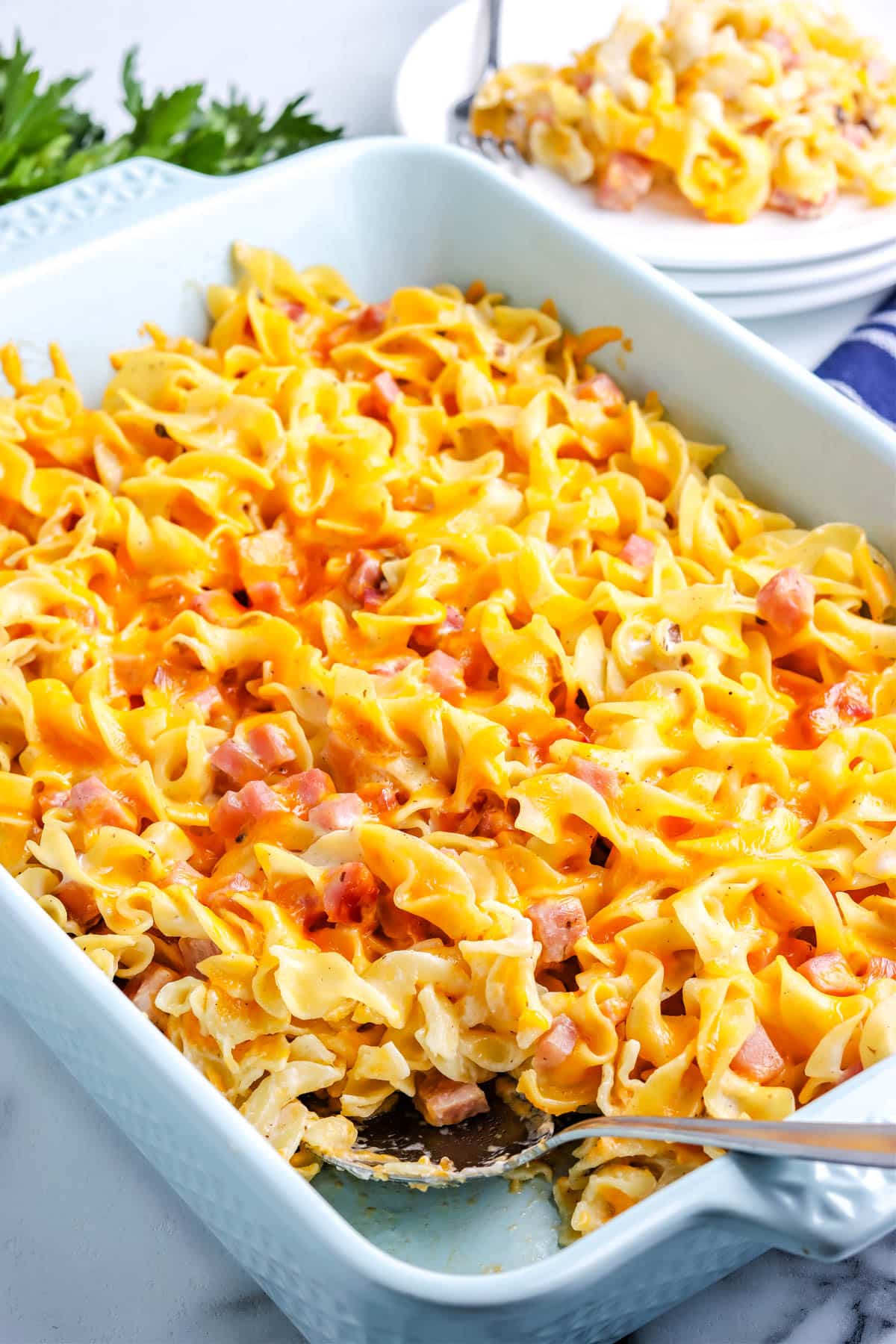 The finished Ham and Noodle Casserole with a serving spoon in it. 