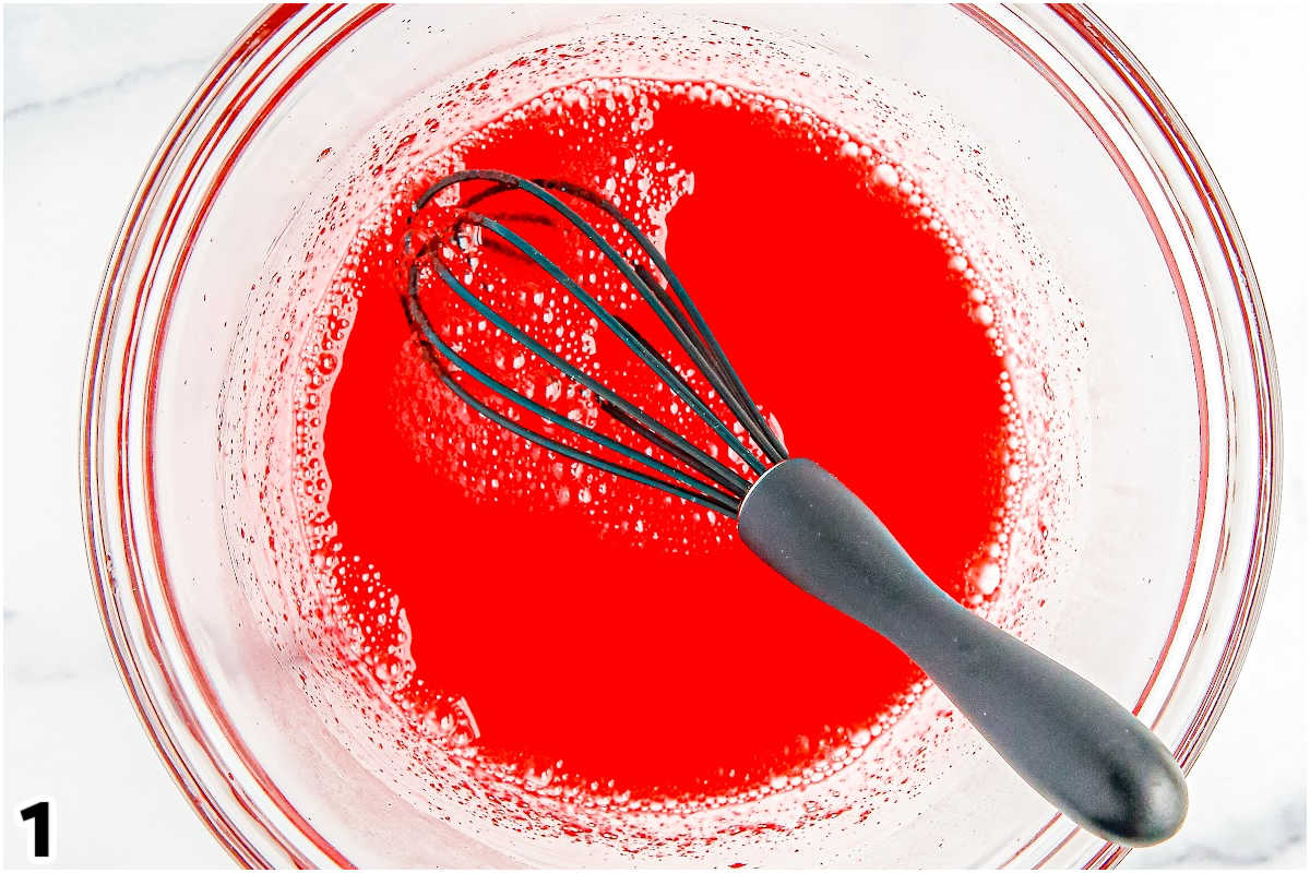 The strawberry Jello whicked with water in a bowl.