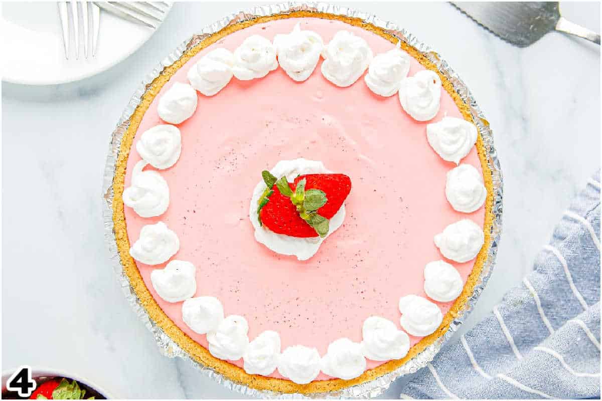 The finished Cool Whip Strawberry Jello Pie garnished with Cool Whip and strawberries.