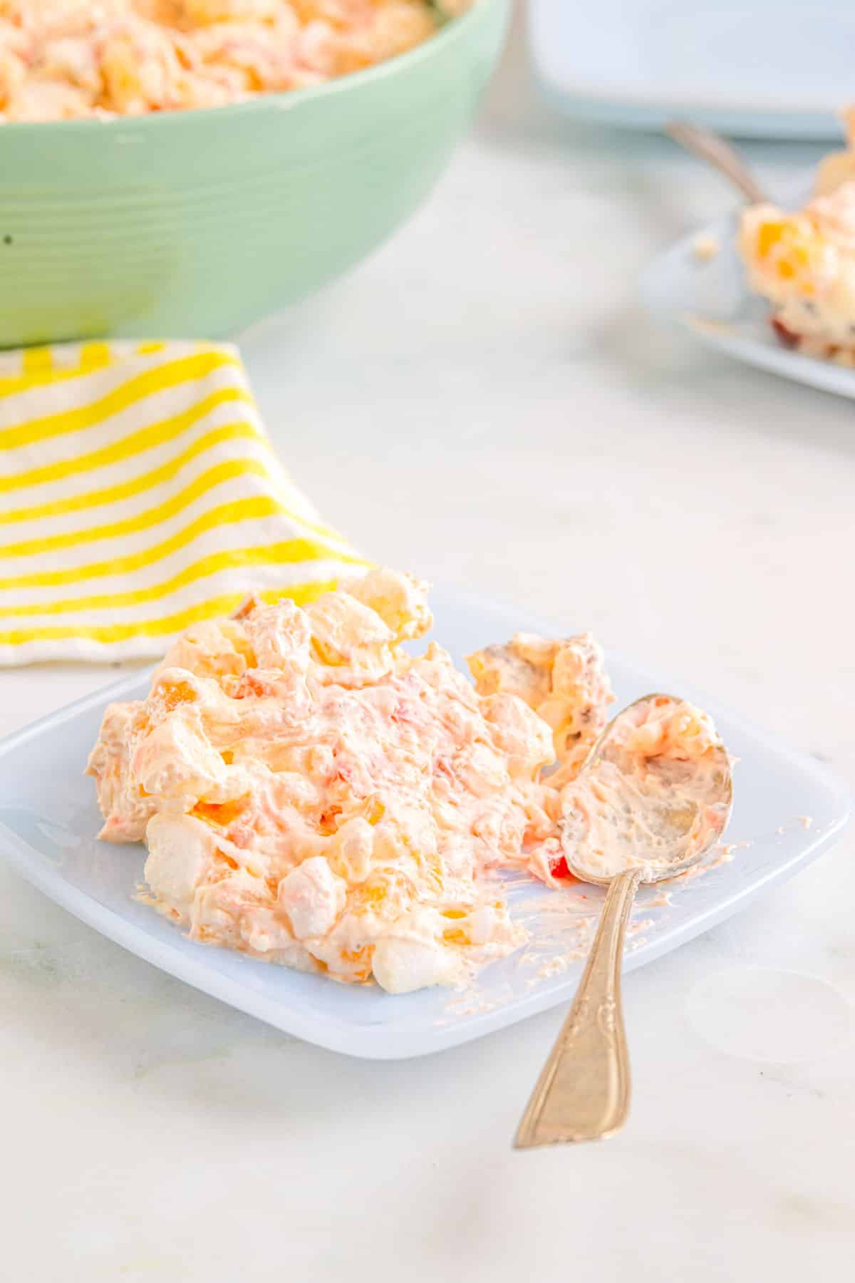 The finished recipe for pineapple fluff on a plate with a spoon.