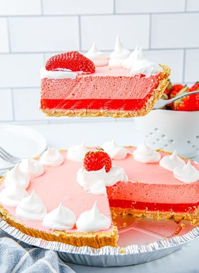 A slice being taken out of the finished Strawberry Jello Pie.