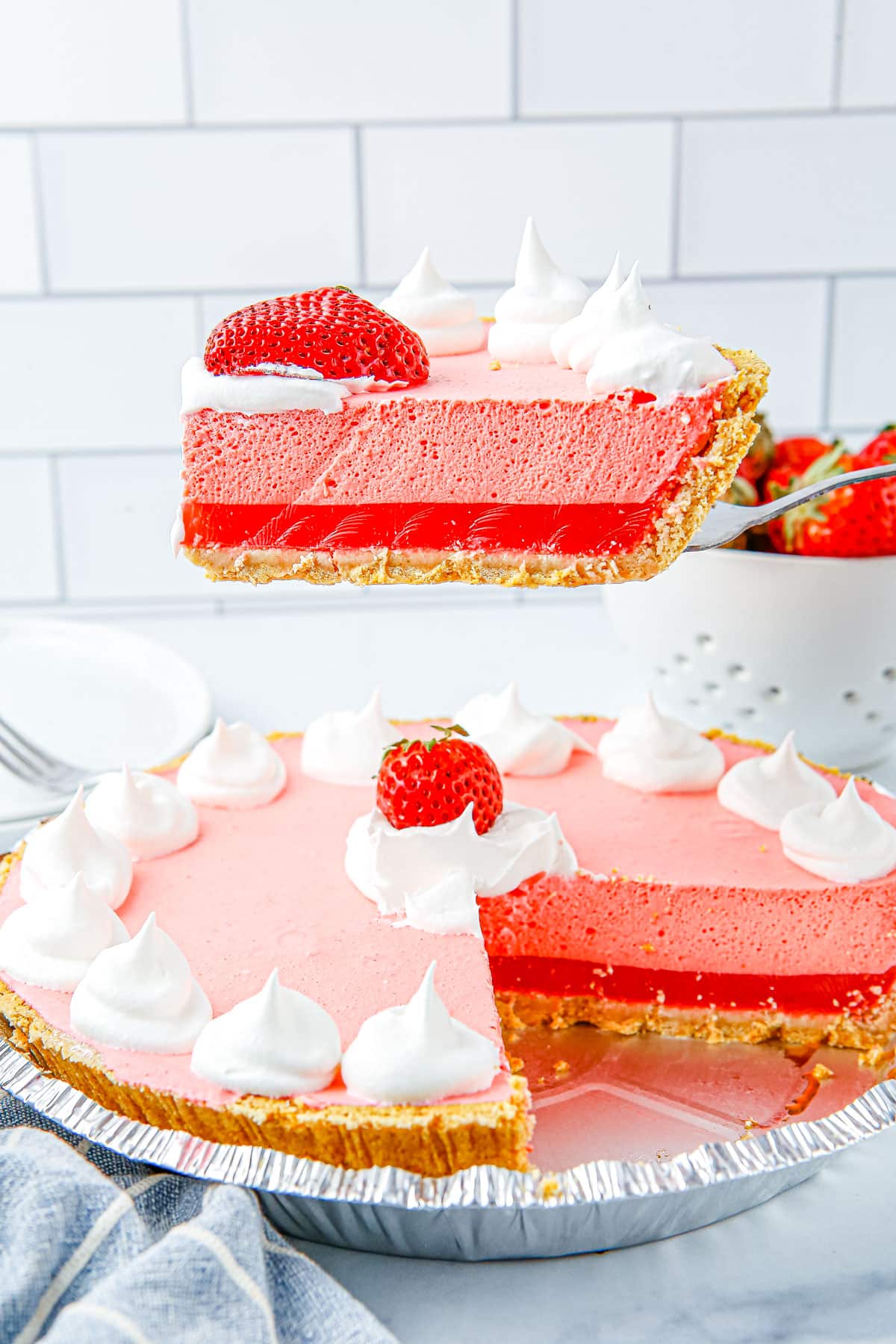 A slice being taken out of the finished Strawberry Jello Pie. 