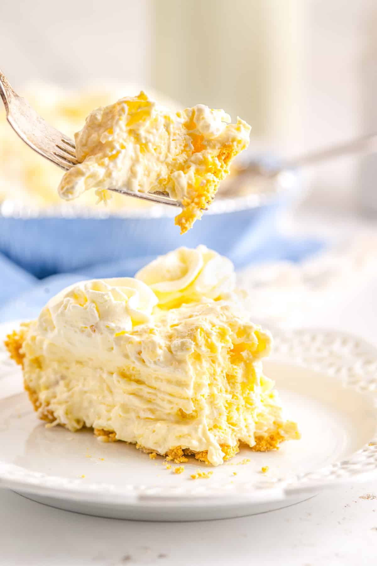 A fork taking a forkful out of a slice of Cream Cheese Pineapple Pie.