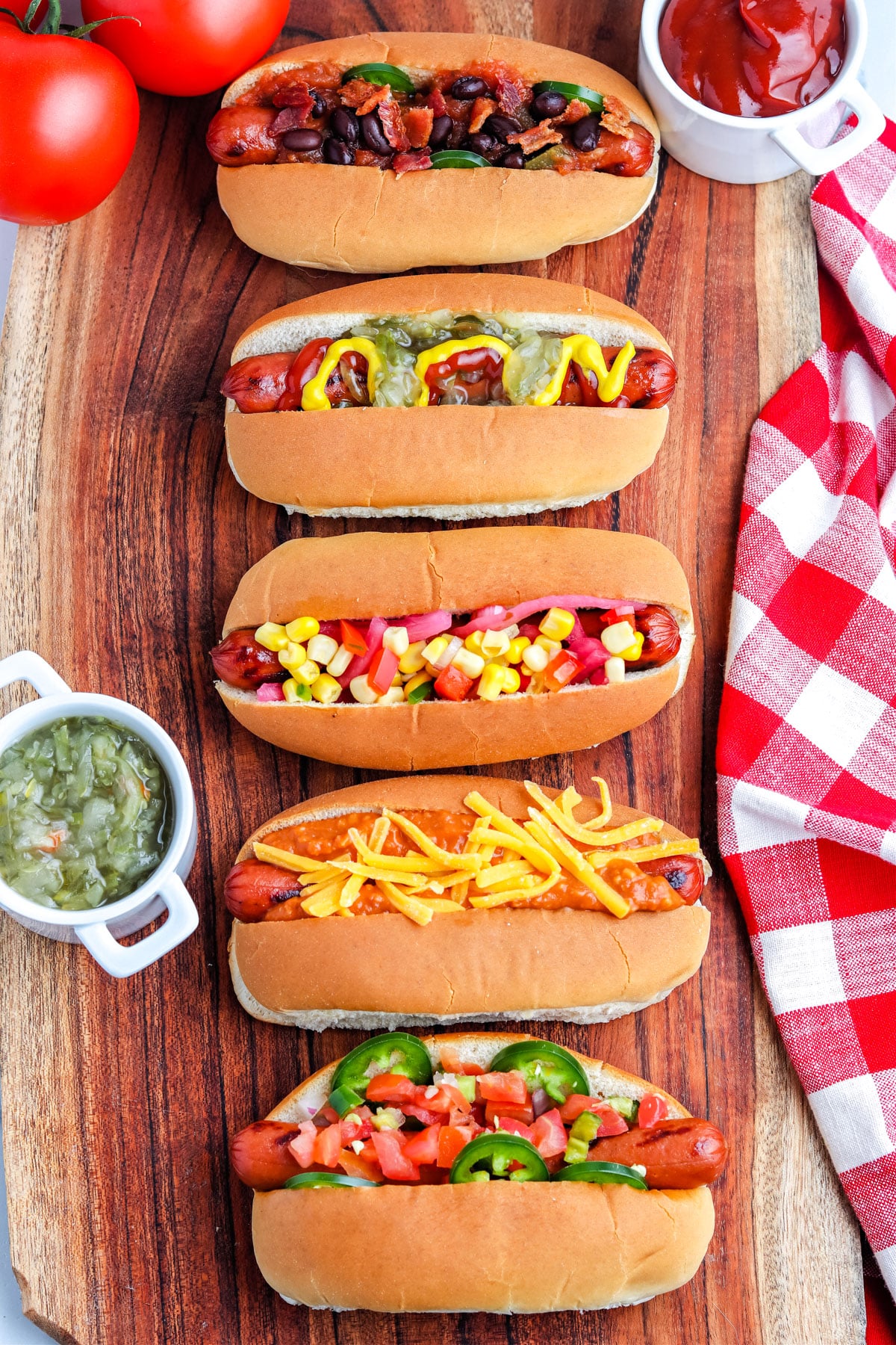 Five Grilled Hot Dogs all with different toppings.