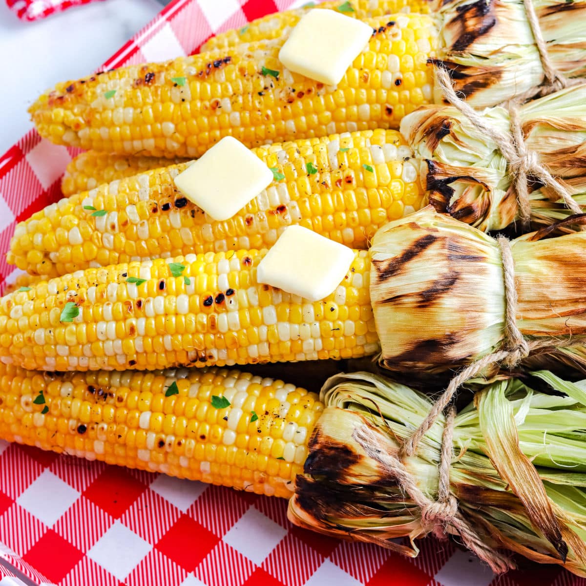The finished Grilled Corn On The Cob In Husk on a serving platter.