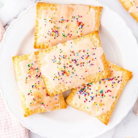 Four Strawberry Pop Tarts on a white plate.
