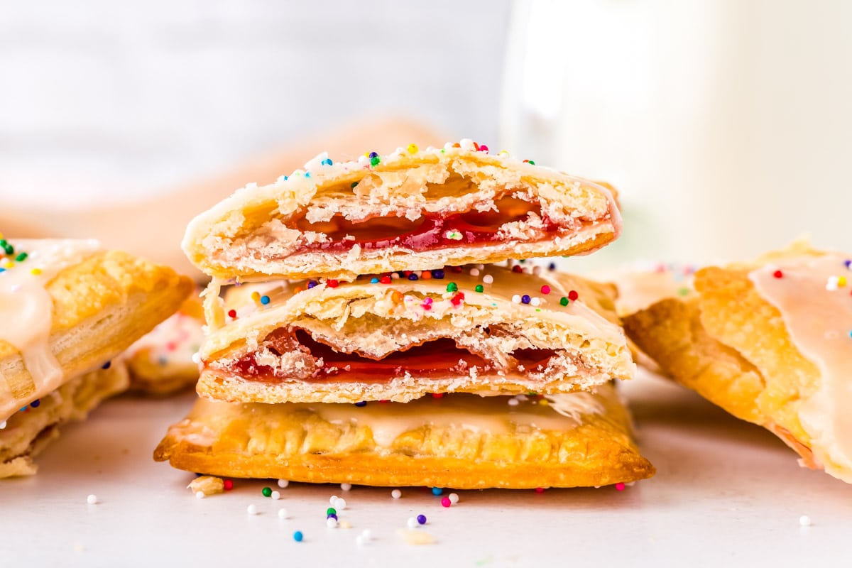 Three Strawberry Pop Tarts stacked on top of each other and cut in half so you can see what the inside looks like.