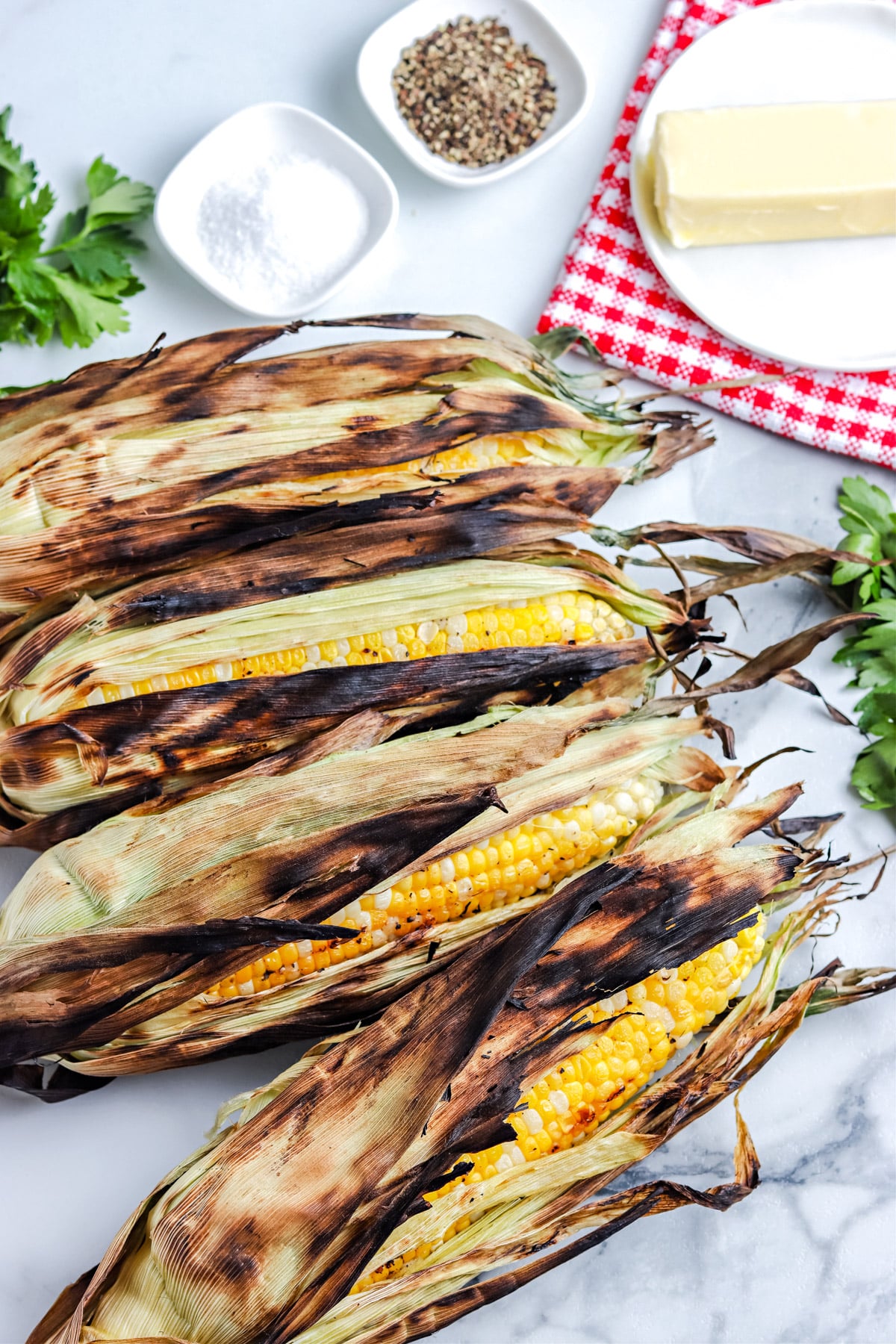 The finished Grilled Corn On The Cob In Husk on a serving platter.