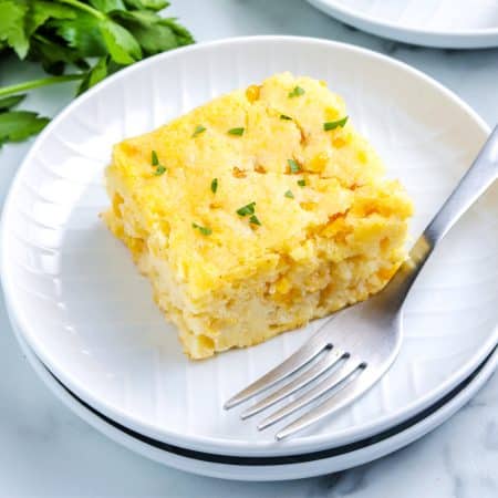 A piece of Corn Casserole on a white plate.