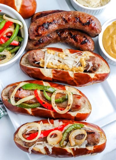 An overhead picture of three Grilled Brats in rolls.