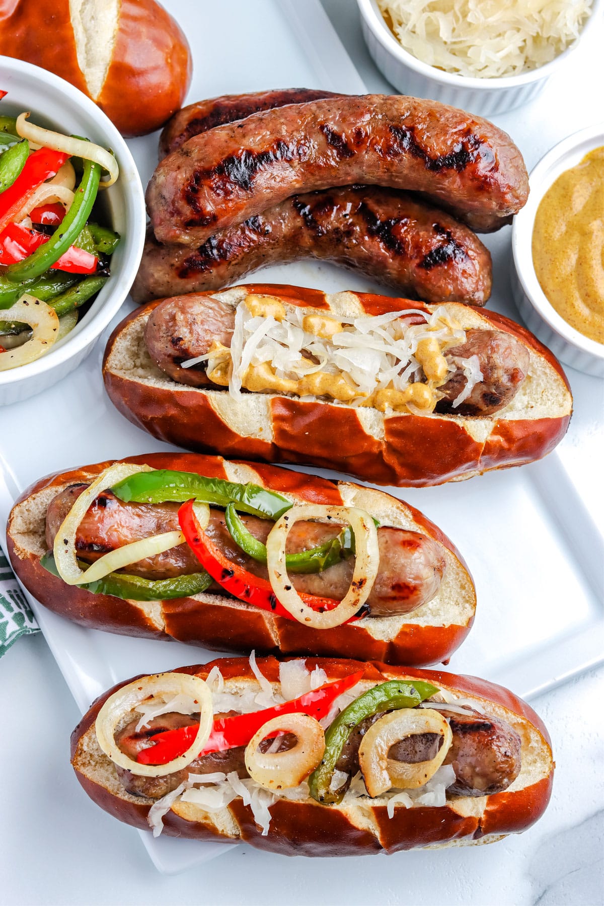 An overhead picture of three Grilled Brats in rolls. 